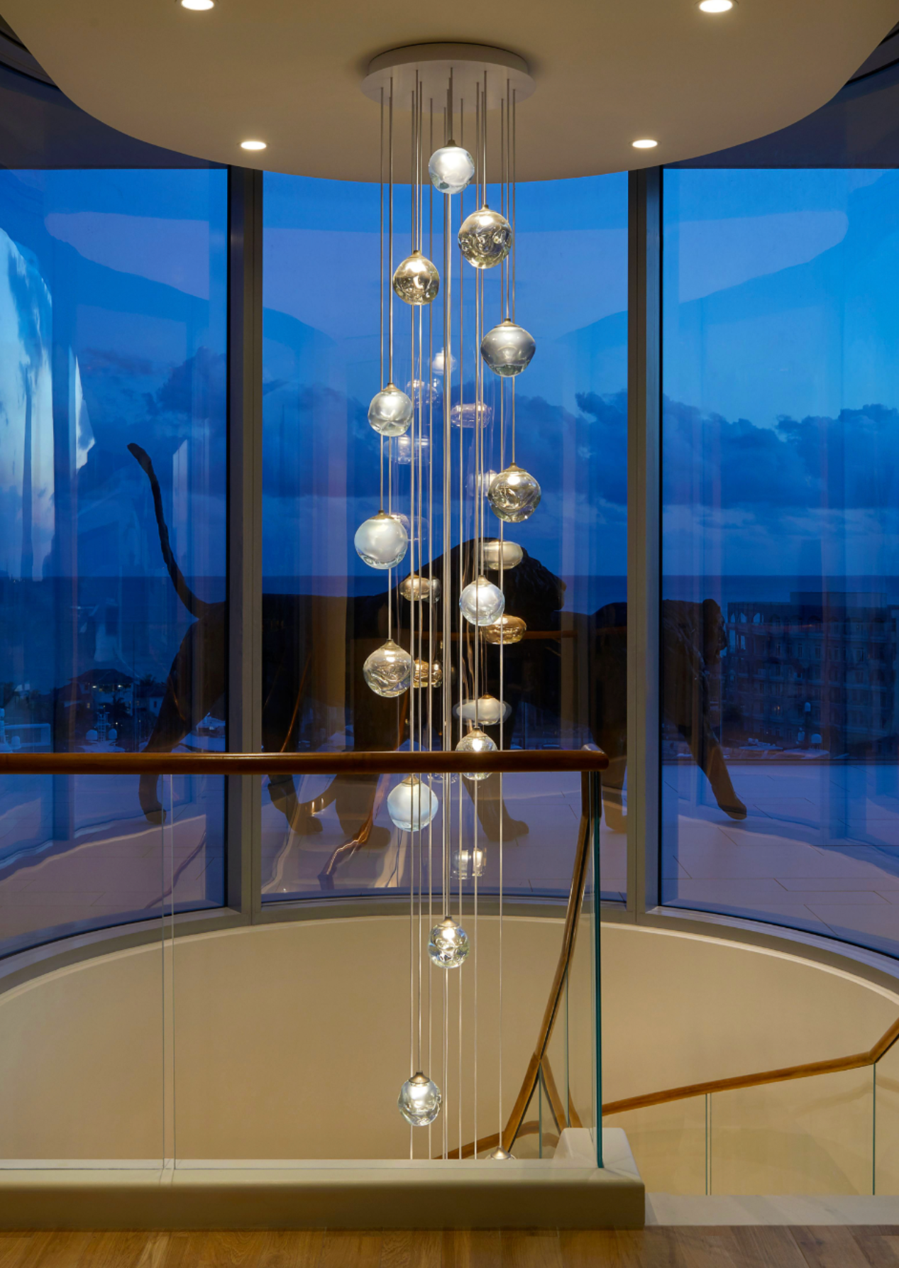 cascading pendants at dusk through a spiral stair case